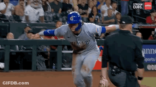 A Baseball Player Wearing A Chicago Cubs Uniform Is Running Towards The Catcher GIF