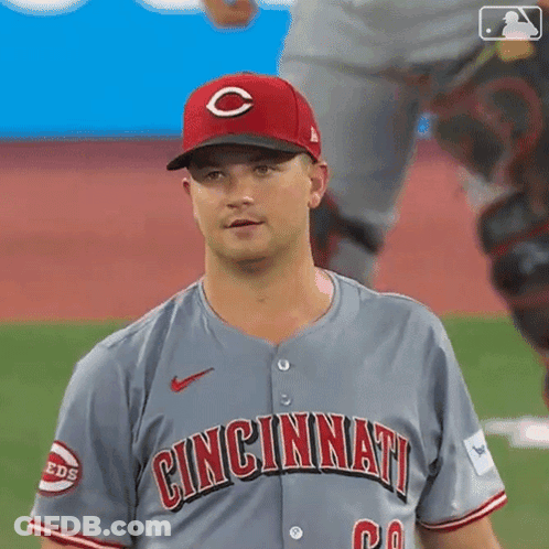 A Baseball Player Wearing A Cincinnati Jersey Is Standing On The Field . GIF