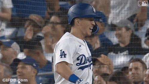 A Baseball Player Wearing A Dodgers Jersey Is Standing In Front Of A Crowd GIF