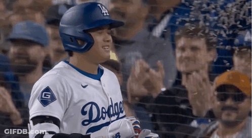 A Baseball Player Wearing A Dodgers Uniform Is Standing In Front Of A Crowd GIF