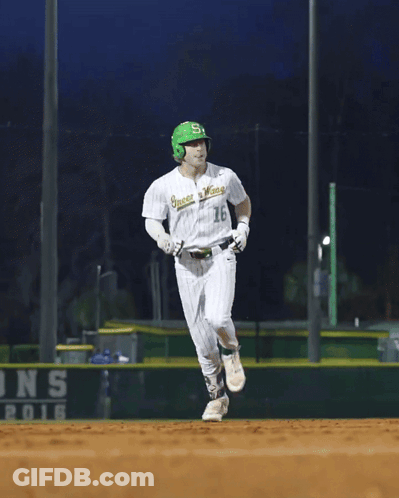 A Baseball Player Wearing A Green Helmet And A White Jersey That Says ' Greenies ' On It GIF