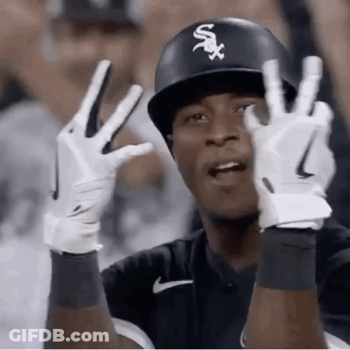 A Baseball Player Wearing A Helmet And Gloves Is Giving The Peace Sign . GIF
