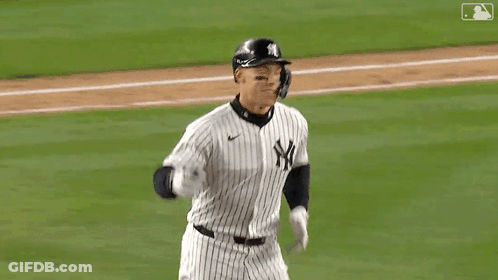 A Baseball Player Wearing A Helmet And Gloves Is Saluting The Crowd . GIF