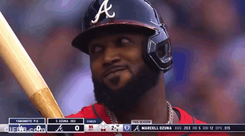 A Baseball Player Wearing A Helmet And Holding A Bat GIF