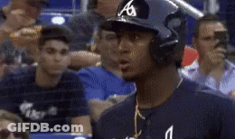 A Baseball Player Wearing A Helmet Stands In A Crowd Of People GIF