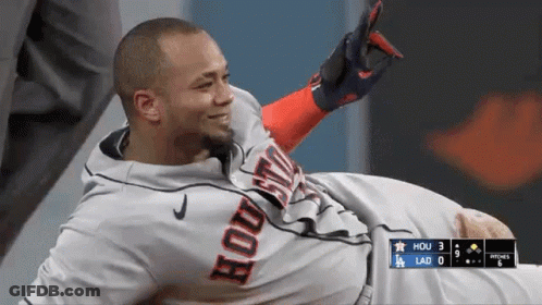 A Baseball Player Wearing A Houston Jersey Is Laying On The Ground . GIF