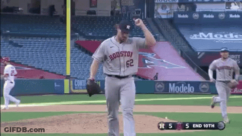 A Baseball Player Wearing A Houston Jersey Is Throwing A Ball While Another Player Runs Behind Him . GIF