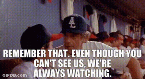A Baseball Player Wearing A La Hat Is Talking To Another Player In A Dugout . GIF