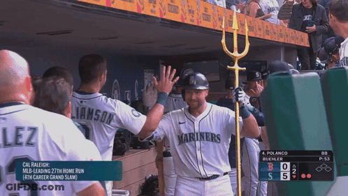 A Baseball Player Wearing A Mariners Jersey High Fives His Teammates GIF