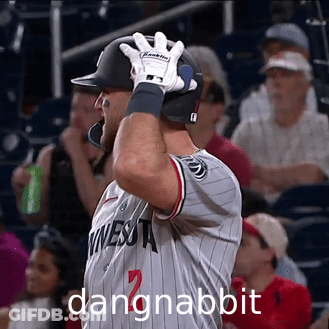 A Baseball Player Wearing A Minnesota Jersey Holds His Helmet Up GIF