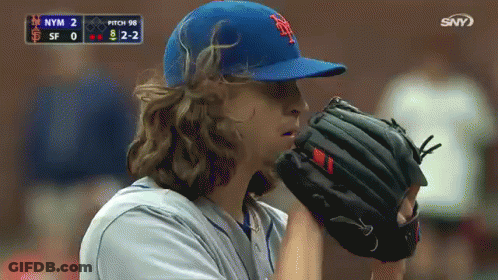 A Baseball Player Wearing A New York Mets Hat And Glove GIF