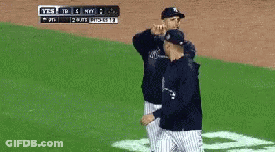 A Baseball Player Wearing A New York Yankees Hat Is Smoking A Cigarette In Front Of A Crowd . GIF