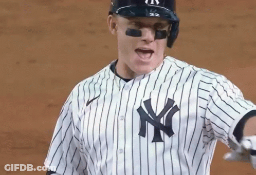 A Baseball Player Wearing A New York Yankees Uniform Is Standing On A Field . GIF