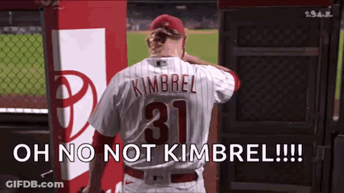A Baseball Player Wearing A Number 31 Jersey Is Standing In The Dugout . GIF