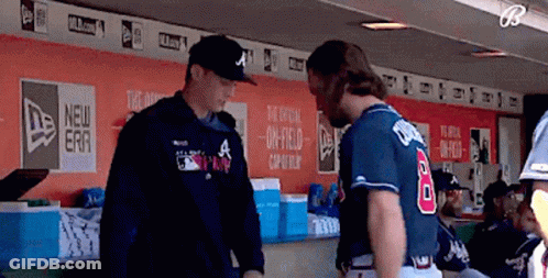 A Baseball Player Wearing A Number 8 Jersey Talks To Another Player In A Dugout GIF