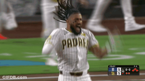 A Baseball Player Wearing A Padres Jersey Is Celebrating On The Field GIF