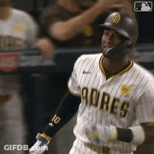 A Baseball Player Wearing A Padres Uniform Is Swinging His Bat At A Pitch . GIF