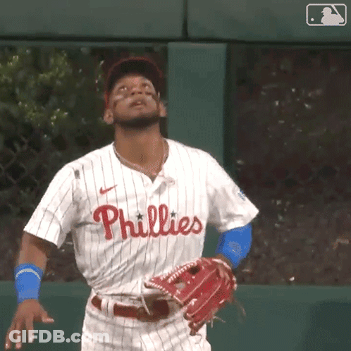 A Baseball Player Wearing A Phillies Jersey Is Looking Up At The Sky GIF