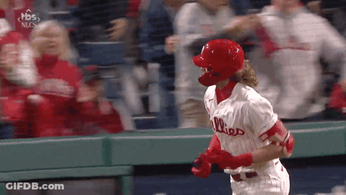 A Baseball Player Wearing A Phillies Jersey Is Running Towards The Dugout GIF