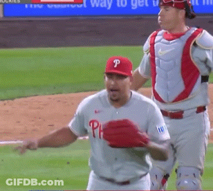 A Baseball Player Wearing A Phillies Jersey Stands On The Field GIF