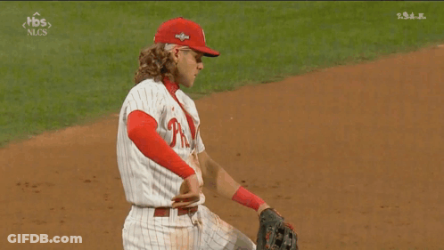 A Baseball Player Wearing A Phillies Uniform Is Kneeling On The Field GIF