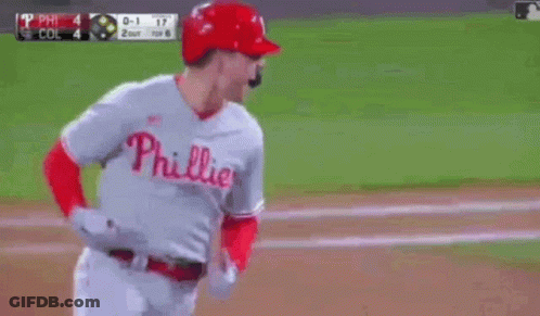 A Baseball Player Wearing A Phillies Uniform Is Running On The Field . GIF