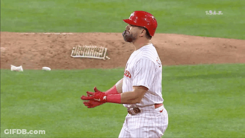 A Baseball Player Wearing A Phillies Uniform Is Standing On The Field GIF