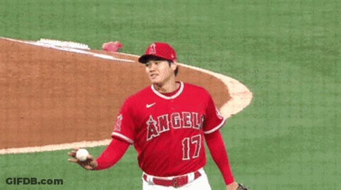 A Baseball Player Wearing A Red Angels Jersey Is Shaking Hands With Another Player GIF