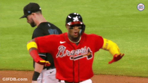 A Baseball Player Wearing A Red Braves Jersey Is Running On The Field GIF