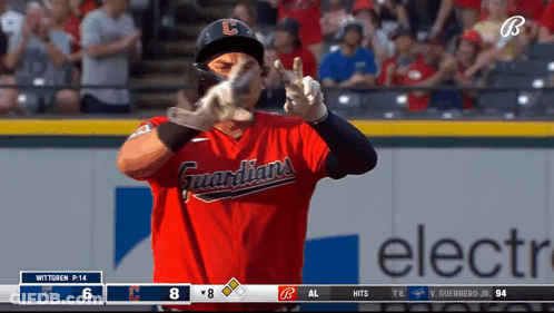 A Baseball Player Wearing A Red Guardians Jersey Makes A Peace Sign GIF