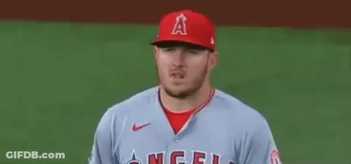 A Baseball Player Wearing A Red Hat And A Grey Jersey Is Standing On The Field . GIF