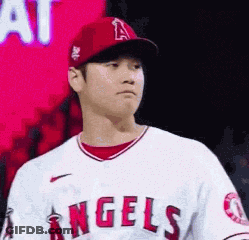 A Baseball Player Wearing A Red Hat And A White Jersey Is Standing In Front Of A Red Background . GIF