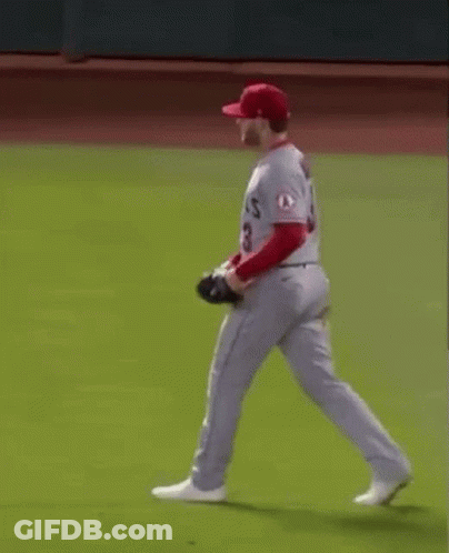A Baseball Player Wearing A Red Hat And White Pants Is Running On A Baseball Field . GIF