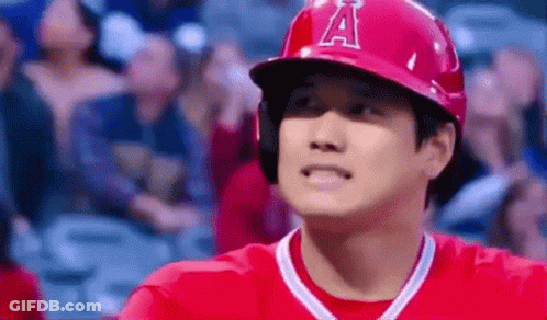 A Baseball Player Wearing A Red Helmet And A Red Shirt Is Standing In Front Of A Crowd At A Baseball Game . GIF