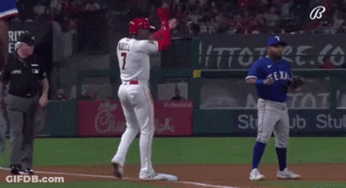 A Baseball Player Wearing A Red Helmet Is Standing In Front Of A Blue Player . GIF
