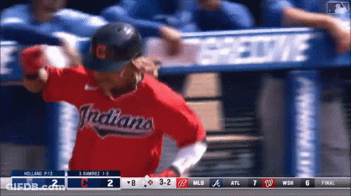 A Baseball Player Wearing A Red Indians Jersey Runs To Home Plate GIF
