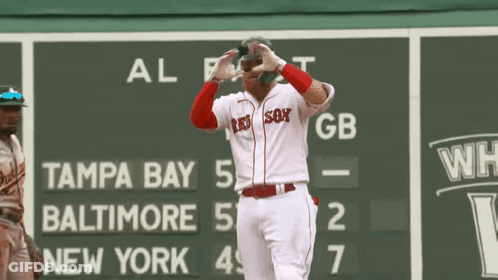 A Baseball Player Wearing A Red Sox Jersey Is Standing In Front Of A Scoreboard GIF