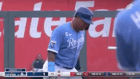 A Baseball Player Wearing A Royals Jersey Is Standing On The Field . GIF