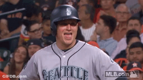 A Baseball Player Wearing A Seattle Jersey Stands In The Stands GIF