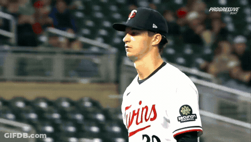 A Baseball Player Wearing A Twins Uniform Stands In The Outfield GIF