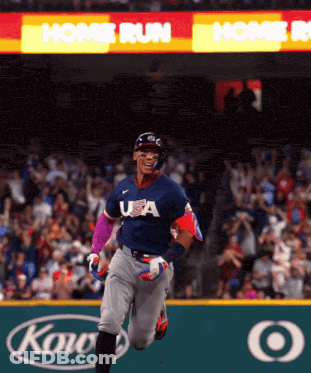 A Baseball Player Wearing A USA Jersey Is Running Towards Home Plate GIF