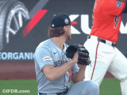 A Baseball Player Wearing A Washington Jersey Is Kneeling Down GIF