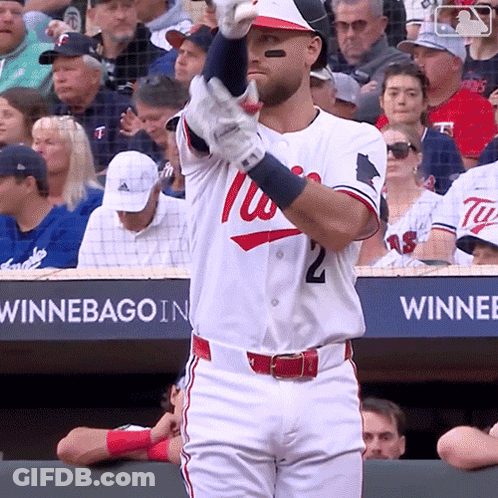A Baseball Player Wearing A Washington Nationals Uniform Holds Up His Bat GIF