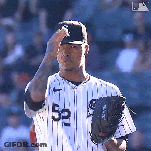 A Baseball Player Wearing A White And Black Uniform With The Number 52 On It GIF
