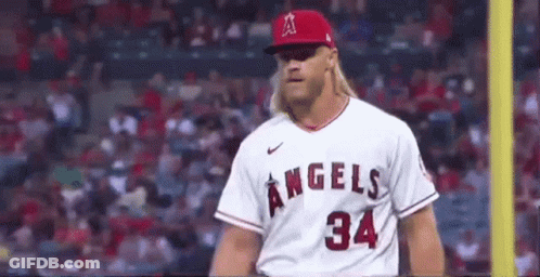 A Baseball Player Wearing A White Jersey With The Number 34 On It Is Standing On A Field . GIF