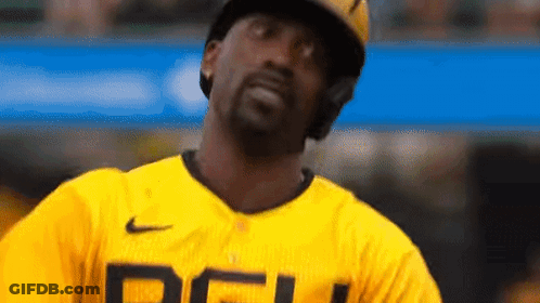 A Baseball Player Wearing A Yellow Jersey And A Helmet Is Looking Up At The Sky . GIF