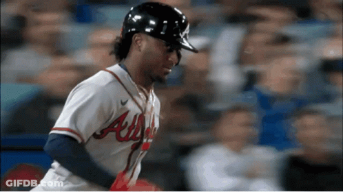 A Baseball Player Wearing An Atlanta Uniform Looks Down At Something GIF