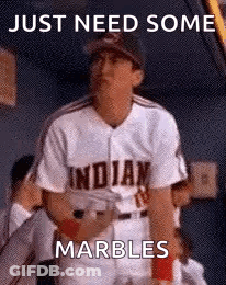 A Baseball Player Wearing An Indians Jersey Is Standing In The Dugout . GIF