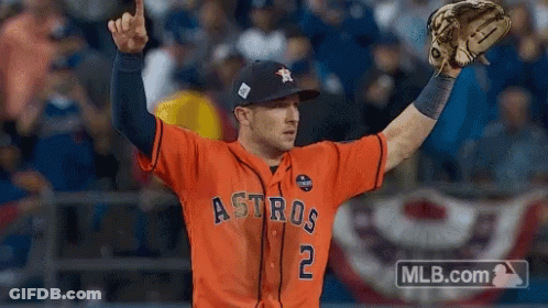 A Baseball Player Wearing An Orange Astros Jersey Holds His Glove Up In The Air GIF