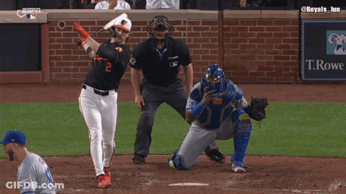 A Baseball Player Wearing An Orioles Jersey Is Talking To A Referee GIF